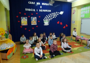 dzieci siedzą na dywanie