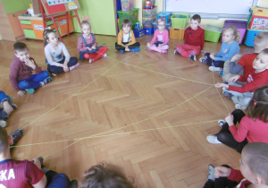 dzieci tworzą ,,pajęczynkę przyjaźni" z wełny