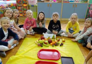 dziewczynki siedzą wokoł owoców
