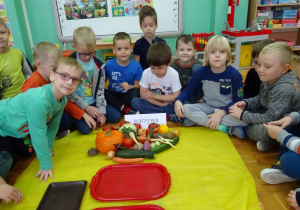 chłopcy siedzą wokół warzyw
