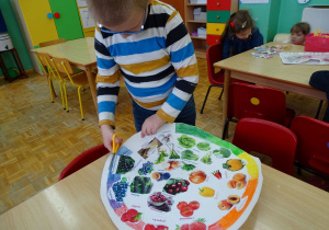 chłopiec wycina kolorowy talerz