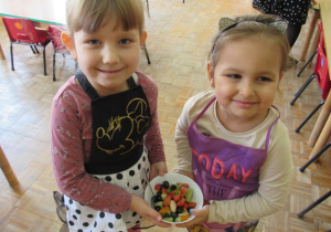 Konsumowanie sałatki owocowej przez dzieci.