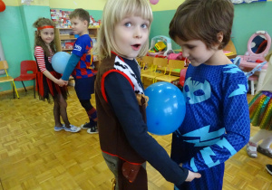 dzieci trzymają balony między brzuszkami