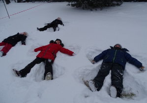 dzieci robią "orzełki" na śniegu