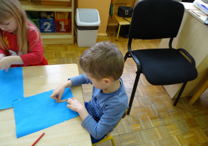 chłopiec maluje przy użyciu gąbki