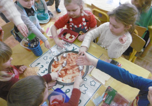 dzieci smarują pizze sosem