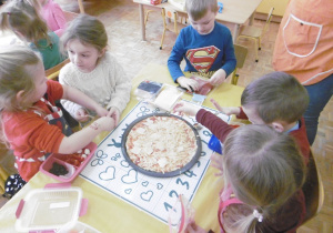 dzieci nakładają składniki na pizze