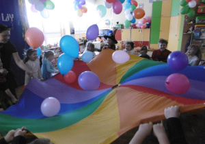 dzieci bawią się chustą animacyjną i balonami