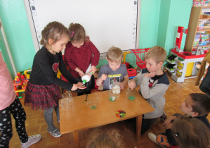 dzieci przygotowują płyn do wykonania eksperymentu