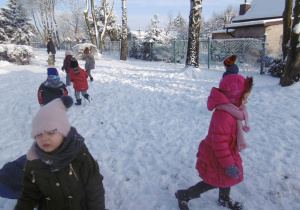 dzieci biegają po śniegu