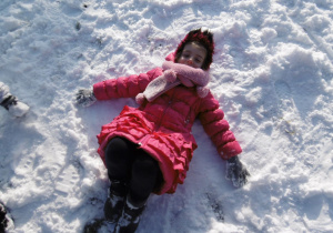 dziewczynka robi ,,aniołka,, na śniegu