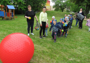 Rzucanie balonów wypełnionych przez dzieci do dużej piłki.