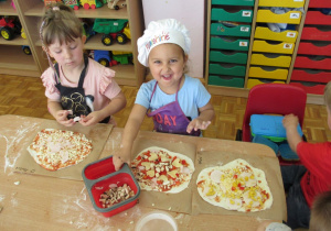 Dzieci oczekują na włożenie pizzy do piekarnika.